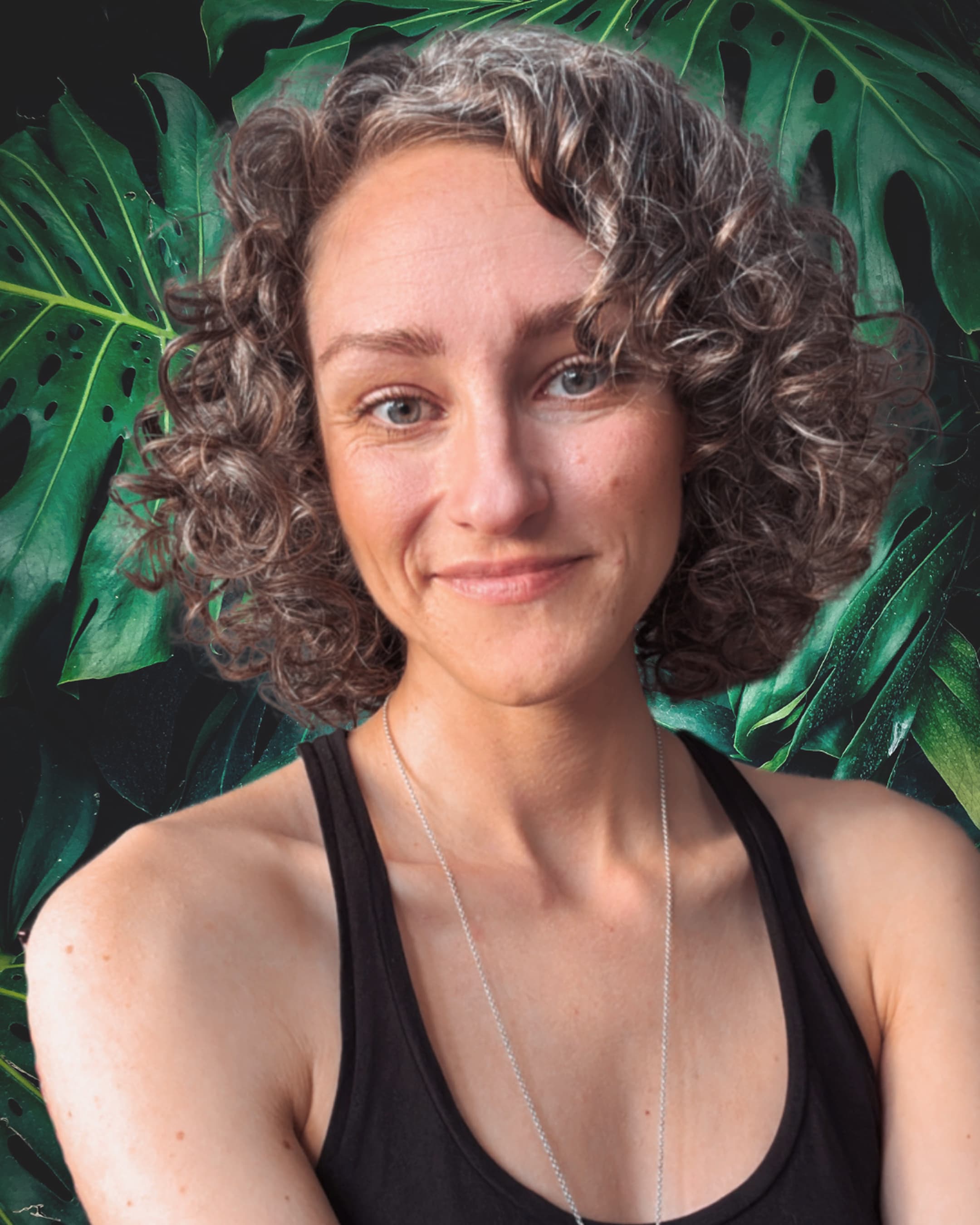 portrait of Natalie Stoemmer, founder of the Baba Yaga menstrual cycle coach app, smiling in front of a green natural background